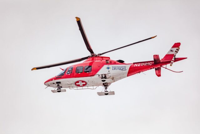 red helicopter in flight made of hybrid composite metal components