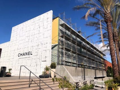Commercial retail building under construction with SMARTci building enclosure system installed behind scaffolding.