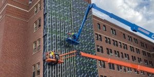 Installers on two elevated lifts installing GreenGirt CMH Delta Adjustable continuous insulation over WRB on the Yale New Haven Hospital building in New Haven, CT.